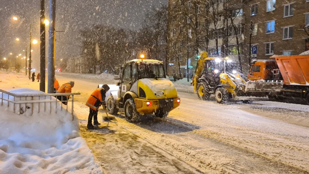 Municipal workers clear snow from the sidewalks and a road after heavy snowfall in Moscow, Russia, Monday, Dec. 4, 2023. A record snowfall has hit Russia's capital bringing an additional 10 cm (3,9 inches) to already high levels of snow and causing disruption at the capital's airports and on roads. (Denis Voronin)/Moscow News Agency via AP)