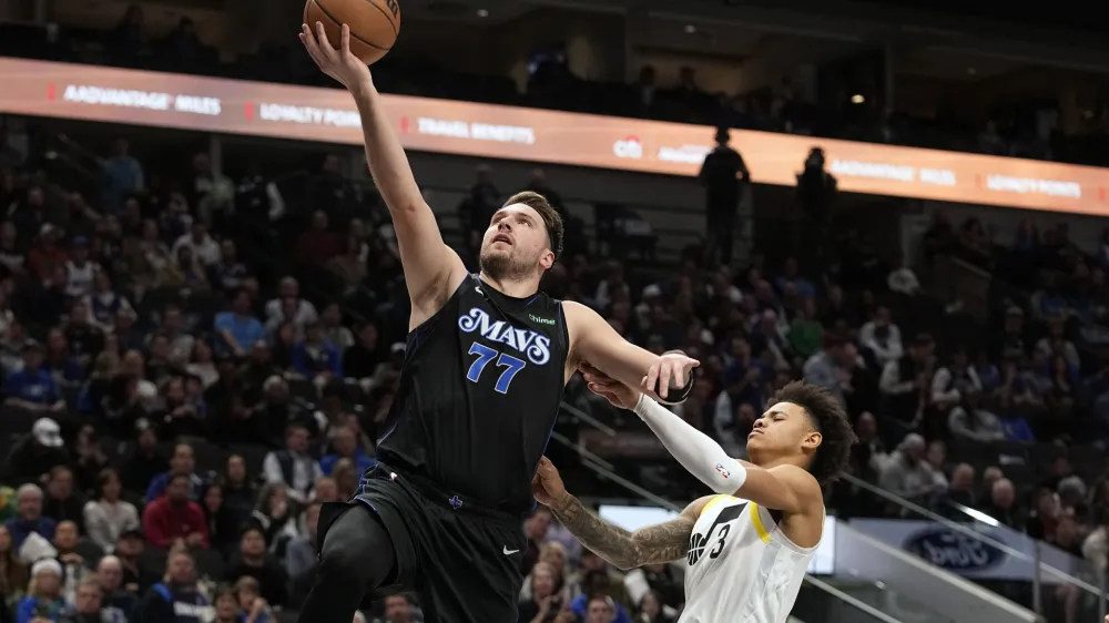 Dallas Mavericks guard Luka Doncic (77) scores past Utah Jazz guard Keyonte George (3) during the second half of an NBA basketball game in Dallas, Wednesday, Dec. 6, 2023. (AP Photo/LM Otero)