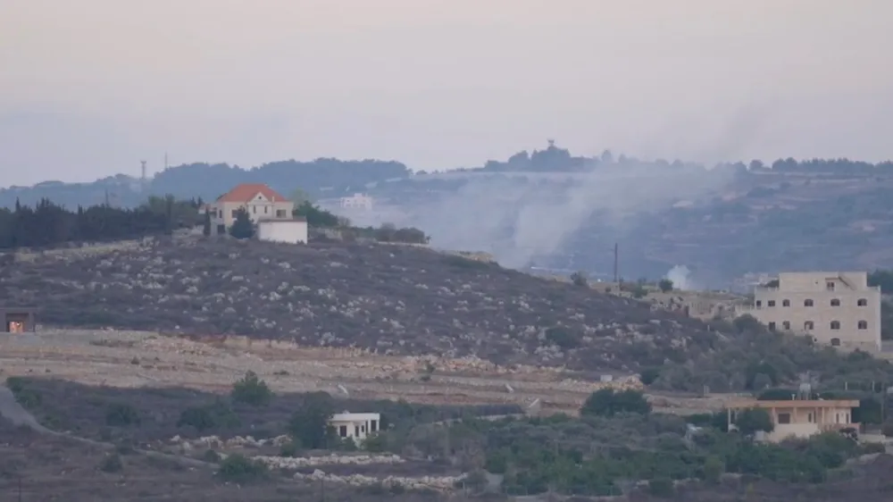 A screenshot from video footage provided to Reuters by Rai that was shot from the Lebanon side of the Israel-Lebanon border, October 13, 2023. The large plumes of smoke rising behind the hill to the right of the orange-roofed building indicate the location, close to the Lebanese village of Alma al-Chaab, that was hit by the first of two rounds fired by an Israeli tank, killing Reuters visuals journalist Issam Abdallah and wounding six other reporters. To match Special Report ISRAEL-LEBANON/JOURNALIST  Rai/Handout via REUTERS  THIS IMAGE HAS BEEN SUPPLIED BY A THIRD PARTY. NO RESALES. NO ARCHIVES. MANDATORY CREDIT.