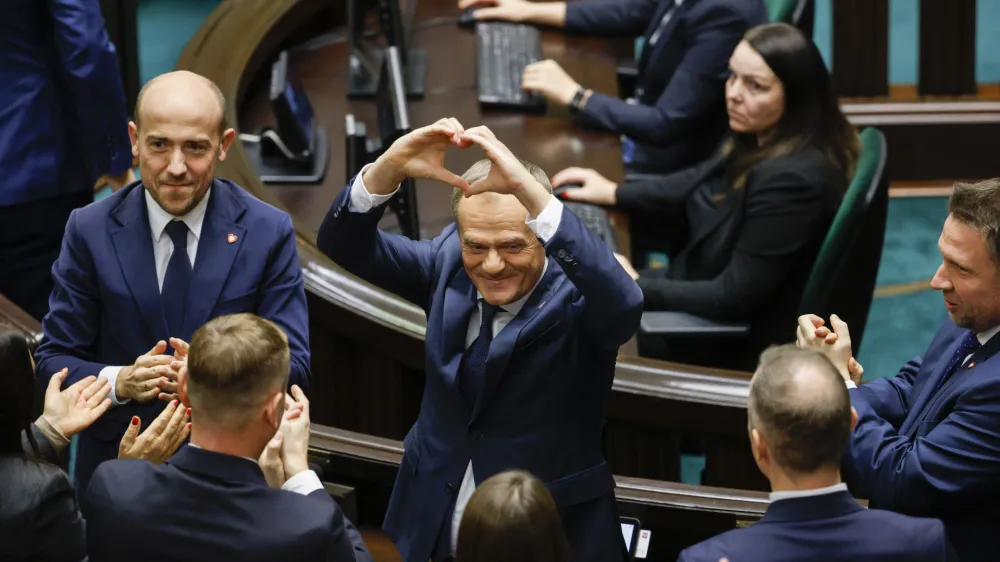 Donald Tusk shows a heart with his hands to lawmakers after he was elected as Poland's Prime Minister at the parliament in Warsaw, Poland, Monday Dec. 11, 2023. (AP Photo/Michal Dyjuk)