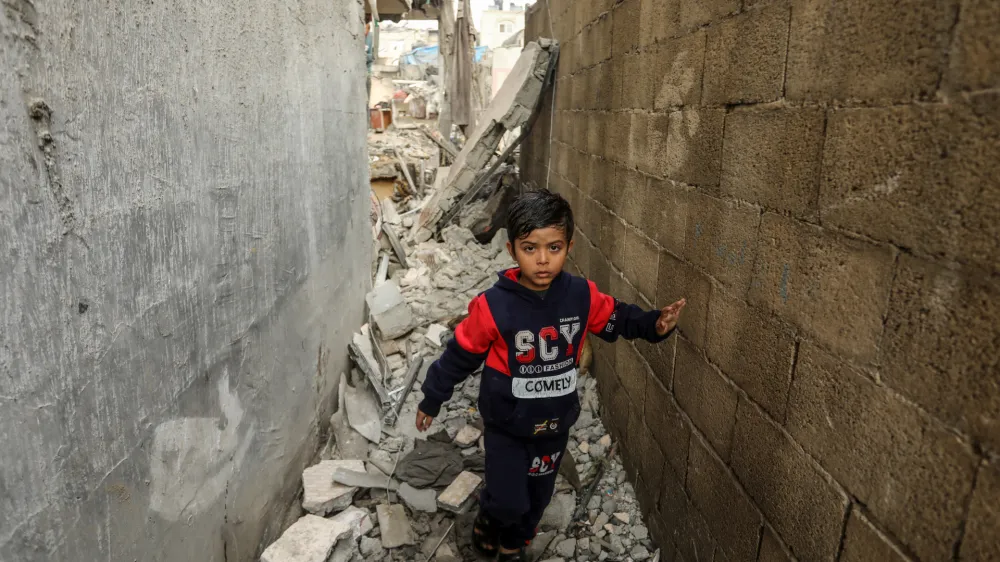 14 December 2023, Palestinian Territories, Rafah: A Palestinian child walks amidst the debris of a destroyed house following Israeli bombardment, amid ongoing battles between Israel and the Palestinian militant group Hamas. Photo: Abed Rahim Khatib/dpa