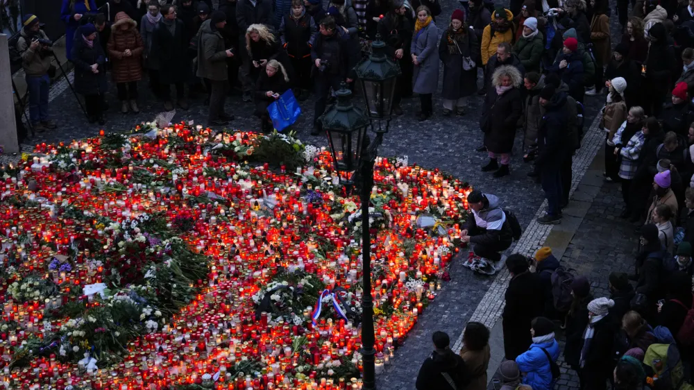 Mourners bring flowers and candles outside the building of Philosophical Faculty of Charles University in Prague, Czech Republic, Friday, Dec. 22, 2023. A lone gunman opened fire at a university on Thursday, killing more than a dozen people and injuring scores of people. (AP Photo/Petr David Josek)