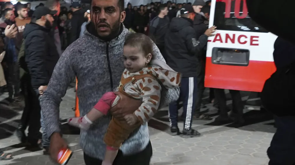 Palestinians wounded in the Israeli bombardment of the Gaza Strip arrive at the hospital in Deir al Balah, Gaza Strip, on Saturday, Dec. 23, 2023. (AP Photo/Adel Hana)