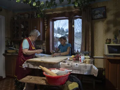 Women make dumplings for a dinner before Christmas celebration in Kryvorivnia village, Ukraine, Sunday, Dec. 24, 2023. (AP Photo/Evgeniy Maloletka)