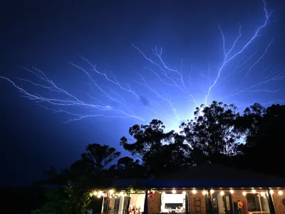 An electrical storm is seen at Reedy Creek on the Gold Coast Monday, December 25, 2023. A woman has died after being struck by a tree after winds of 100 kph lashed the Gold Coast, bringing down trees, powerlines. (AAP Image/Dave Hunt) NO ARCHIVING