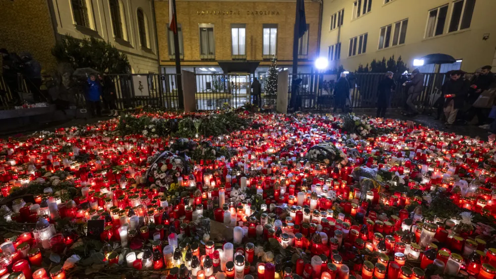 22 December 2023, Czech Republic, Prague: People light candles and place flowers at a makeshift memorial in front of the building of the Faculty of Philosophy of Charles University for the victims of the deadly shooting. On Thursday afternoon, a shooter opened fire at a university in central Prague, killing at least 14 people and injuring 25, 10 of whom were critically. Photo: Říhová Michaela/CTK/dpa