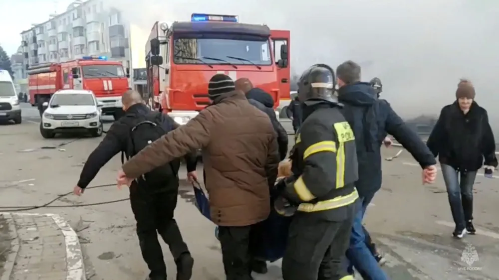 People, including firefighters, carry a person away from the site following what was said to be Ukrainian forces' shelling in the course of Russia-Ukraine conflict, in Belgorod, Russia December 30, 2023, in this still image taken from video. Russian Emergencies Ministry/Handout via REUTERS ATTENTION EDITORS - THIS IMAGE HAS BEEN SUPPLIED BY A THIRD PARTY. NO RESALES. NO ARCHIVES. MANDATORY CREDIT.