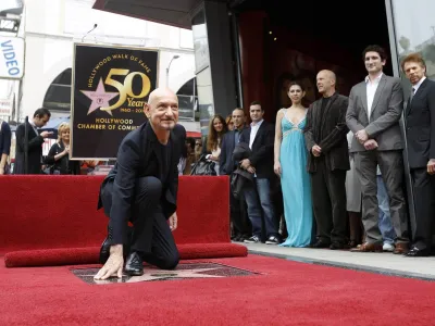 Actor Ben Kingsley touches his star on the "Walk of Fame," as (from R-L) producer Jerry Bruckheimer, son Edmund Kingsley, Bruce Willis, and Kingsley's wife Daniela Lavender stand nearby, in Hollywood, California May 27, 2010. REUTERS/Mario Anzuoni (UNITED STATES - Tags: ENTERTAINMENT)