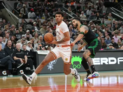 Dec 31, 2023; San Antonio, Texas, USA; San Antonio Spurs forward Dominick Barlow (26) drives past Boston Celtics forward Jayson Tatum (0) in the second half at Frost Bank Center. Mandatory Credit: Daniel Dunn-USA TODAY Sports