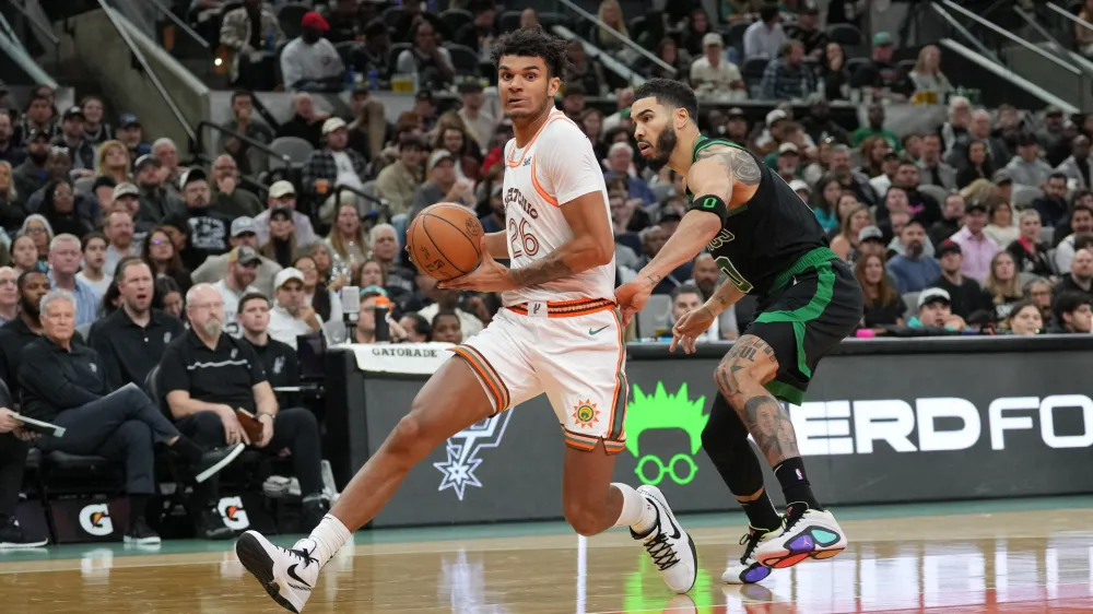 Dec 31, 2023; San Antonio, Texas, USA; San Antonio Spurs forward Dominick Barlow (26) drives past Boston Celtics forward Jayson Tatum (0) in the second half at Frost Bank Center. Mandatory Credit: Daniel Dunn-USA TODAY Sports