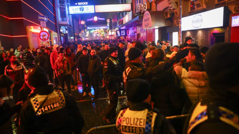 01 January 2024, Hamburg: Police forces block access to the Grosse Freiheit on the Reeperbahn shortly after the turn of the year. Photo: Christian Charisius/dpa