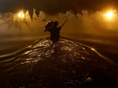 A Venezuelan migrant crosses the Rio Bravo river, the border between the United States and Mexico, with the intention of turning themselves in to the U.S. Border Patrol agents to request asylum, during a day of low temperatures, as seen from Ciudad Juarez, Mexico December 28, 2023. REUTERS/Jose Luis Gonzalez   TPX IMAGES OF THE DAY