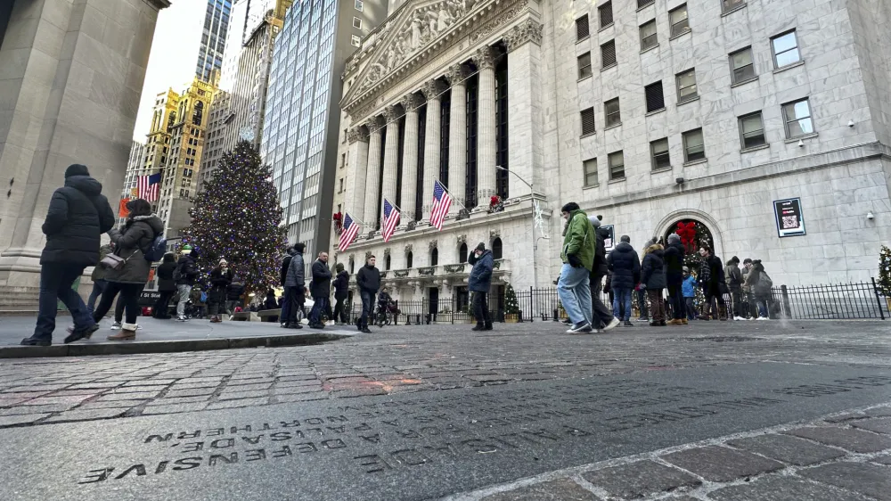 People gather near the New York Stock Exchange on Tuesday, Jan. 2, 2024 in New York. The S&P 500 was lower in midday trading after pulling to the brink of its all-time high set roughly two years ago. (AP Photo/Peter Morgan)