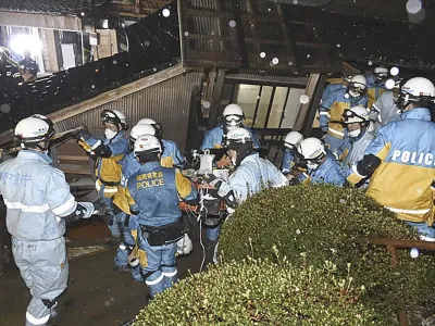 In this photo released by Metropolitan Police Department via Kyodo News, police officers rescue a woman from a collapsed house in Suzu, Ishikawa prefecture, Japan, Saturday, Jan. 6, 2024. The woman in her 90s was pulled alive from the collapsed house late Saturday, 124 hours after a major quake slammed the region, killing scores of people, toppling buildings and setting off landslides. (Metropolitan Police Department/Kyodo News via AP)