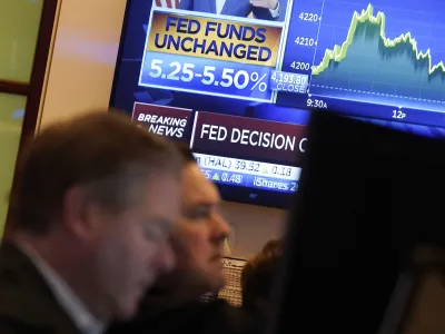 FILE - A television screen shows the rate decision of the Federal Reserve as traders work on the floor of the New York Stock Exchange, Nov. 1, 2023. Inflation has kept slowing, and the economy has withstood the strain of the accumulated higher borrowing costs. On Thursday, Jan. 11, 2024, the Labor Department is expected to report that underlying inflationary pressures eased further in December 2023. (AP Photo/Richard Drew, File)
