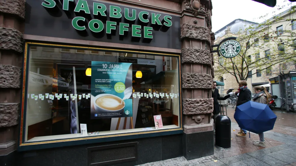 Pedestrians stand next a branch of Starbucks in Frankfurt October 30, 2012. The Seattle-based group, with a market capitalisation of $40 billion, is the second-largest restaurant or cafe chain globally after McDonald's. REUTERS/Ralph Orlowski (GERMANYBUSINESS - Tags: BUSINESS FOOD)