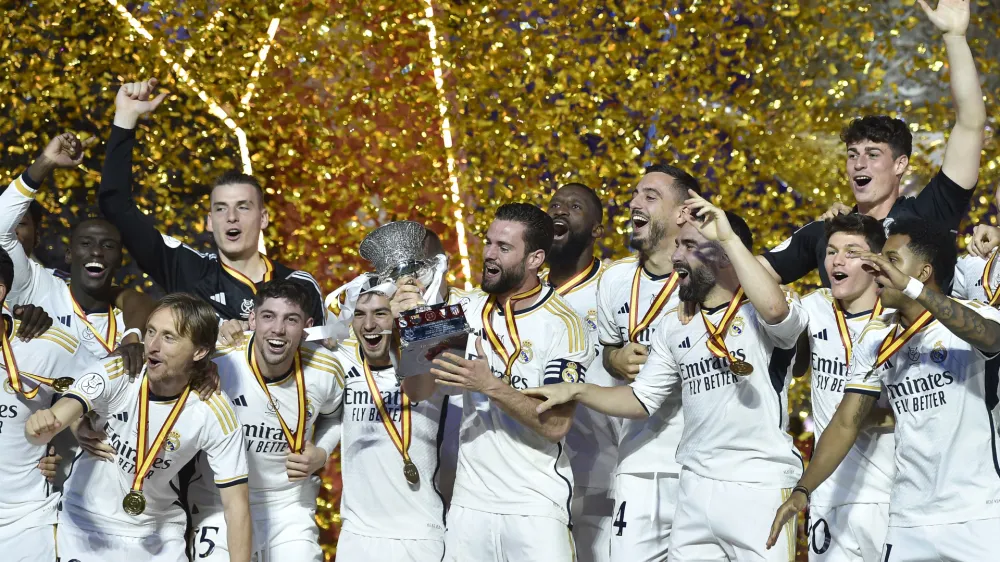 Real Madrid players celebrate with the trophy of the Spanish Super Cup after the final soccer match between Real Madrid and Barcelona at Al-Awwal Park Stadium in Riyadh, Saudi Arabia, Sunday, Jan. 14, 2024. (AP Photo)