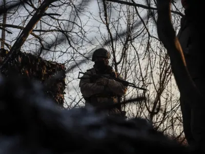 A Ukrainian serviceman stands guard at his position in a trench at a front line on the border with Russia, amid Russia's attack on Ukraine, in Sumy region, Ukraine January 20, 2024. REUTERS/Gleb Garanich