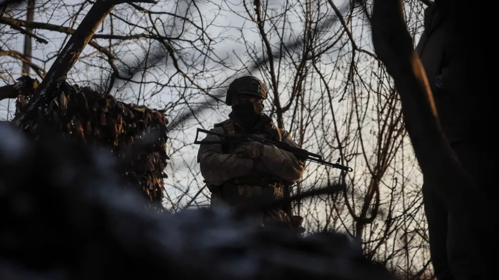 A Ukrainian serviceman stands guard at his position in a trench at a front line on the border with Russia, amid Russia's attack on Ukraine, in Sumy region, Ukraine January 20, 2024. REUTERS/Gleb Garanich
