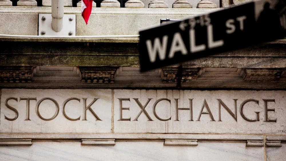 FILE PHOTO: A street sign for Wall Street hangs in front of the New York Stock Exchange May 8, 2013. REUTERS/Lucas Jackso//File Photo