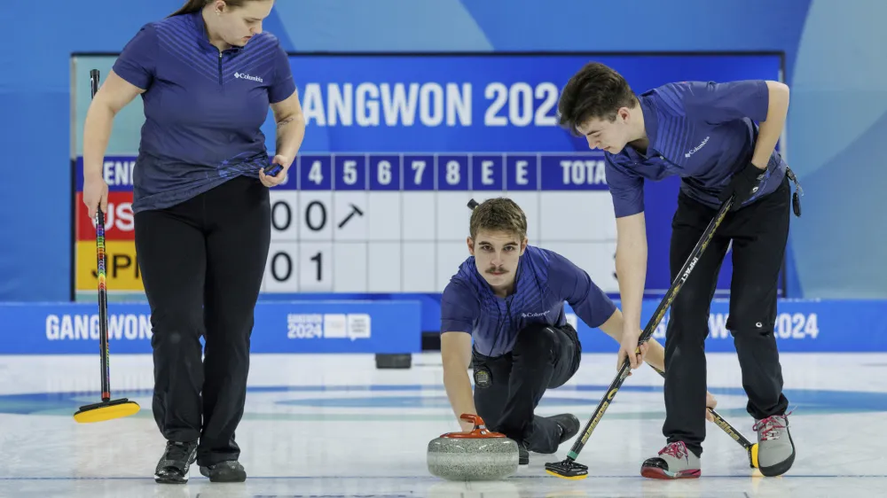 In this photo provided by Olympic Information Services, Owen Robert Nelson, center, of the U.S. releases the stone in the first round of the curling mixed team round robin match against Japan at the Gangneung Curling Centre during the Winter Youth Olympic Games in Gangneung, Gangwon Province, South Korea, Monday, Jan. 22, 2024. (Chloe Knott via OIS)