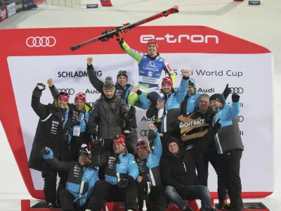 Slovenia's Zan Kranjec celebrates with the Slovenian team his third place in a alpine ski, men's World Cup giant slalom, in Schladming, Austria, Tuesday, Jan. 23, 2024. (AP Photo/Giovanni Auletta)