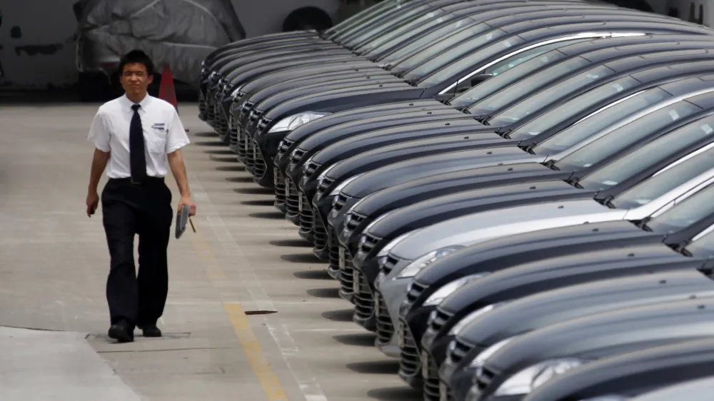 ﻿A man walks past brand new cars at a car dealer in Shanghai, China, Wednesday June 8, 2011. Foreign automakers are seeing mixed sales trends in China as the world's biggest market for new vehicles cools after years of torrid growth. (AP Photo/Eugene Hoshiko)