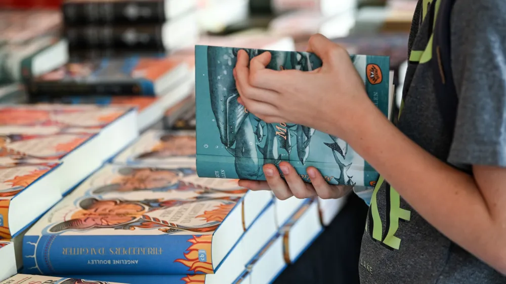 07 September 2022, Berlin: A child holds one of the books during the 22nd Festival for International Children's and Youth Literature at the Haus der Berliner Festspiele. The children's literature festival will take place from 07 to 17 September 2022 at various locations. Photo: Jens Kalaene/dpa