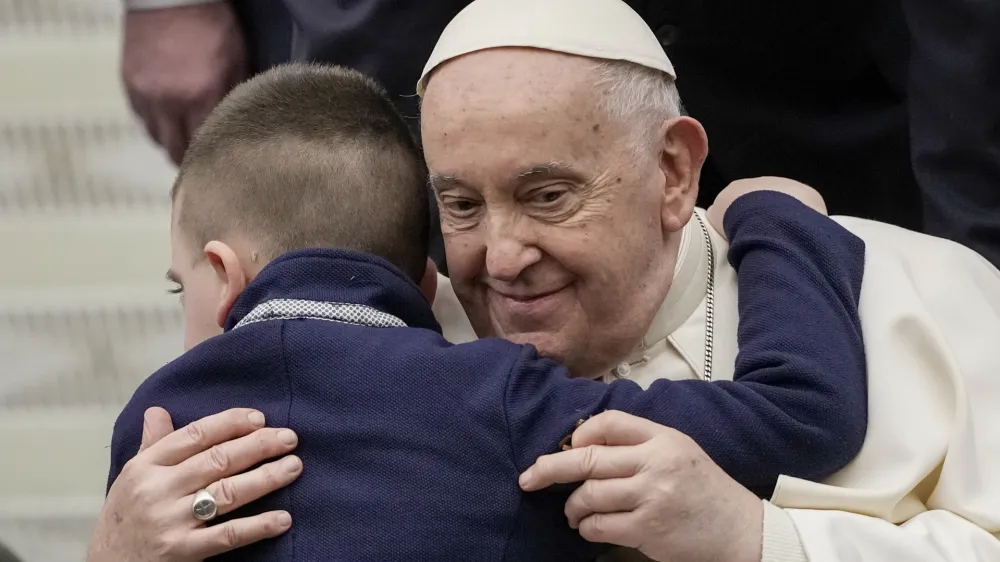 Pope Francis embraces a young boy during his weekly general audience in the Pope Paul VI hall at the Vatican, Wednesday, Jan. 31, 2024. (AP Photo/Andrew Medichini)