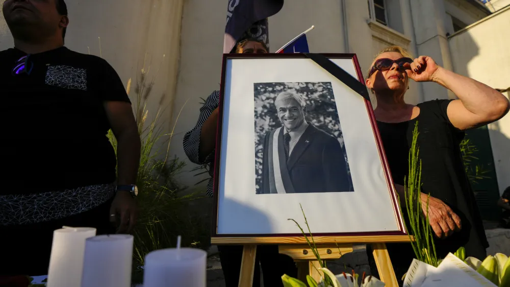 A portrait of the late Chilean President Sebastian Pinera adorns a memorial in the courtyard of the National Renewal political party headquarters, in Santiago, Chile, Tuesday, Feb. 6, 2024. The two-time former president died Tuesday in a helicopter crash. He was 74. (AP Photo/Esteban Felix)