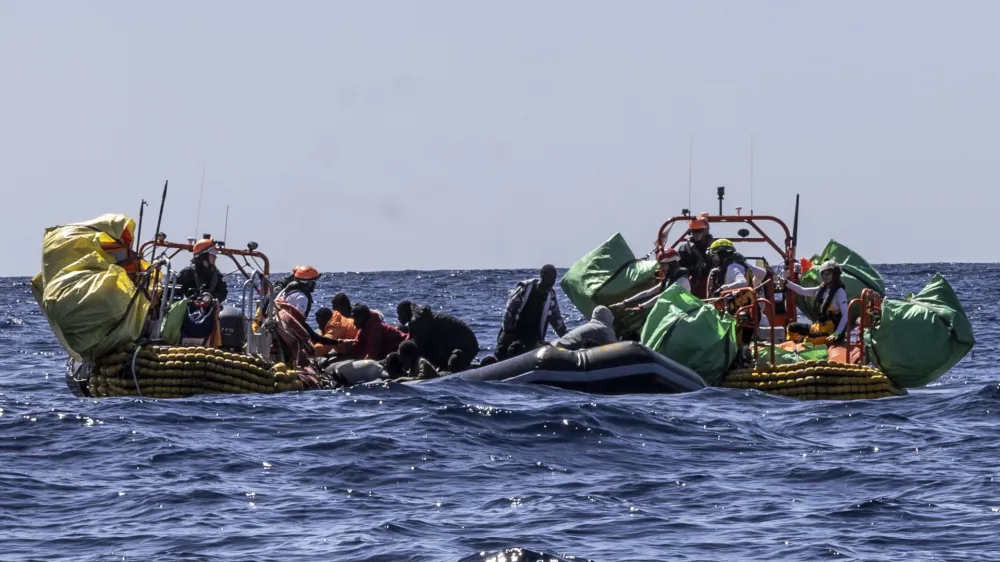 Migrants are helped evacuate a partially deflated rubber dinghy by the rescue personnel of the SOS Mediterranee humanitarian ship Ocean Viking in the Central Mediterranean Sea, Wednesday, March 13, 2024. Survivors reported that some 50 people who departed Libya with them a week ago had perished during the journey. (Johanna de Tessieres/ SOS Mediterranee via AP, HO)