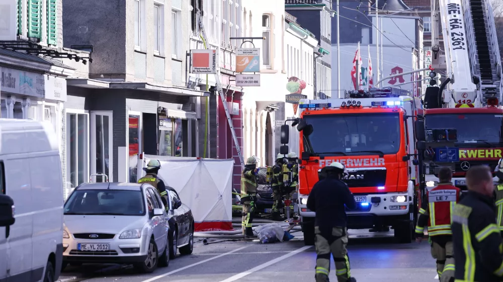 25 March 2024, North Rhine-Westphalia, Solingen: Firefighters and emergency vehicles stand in front of a house where a fire broke out killing three people, including a child. Photo: David Young/dpa