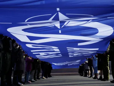 People hold a giant flag with NATO sign as Latvia celebrates anniversary to joining alliance in Riga, Latvia March 28, 2024. REUTERS/Ints Kalnins