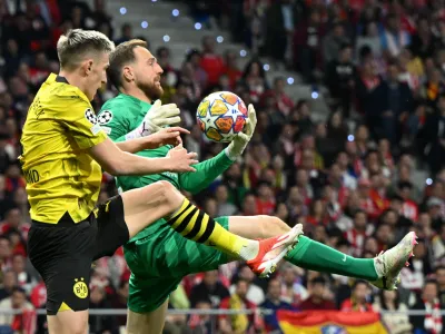 10 April 2024, Spain, Madrid: Madrid goalkeeper Jan Oblak (R) and Dortmund's Nico Schlotterbeck fight for the ball during the UEFA Champions League quarter-finals first leg soccer match between Atletico Madrid and Borussia Dortmund at Wanda Metropolitano. Photo: Federico Gambarini/dpa