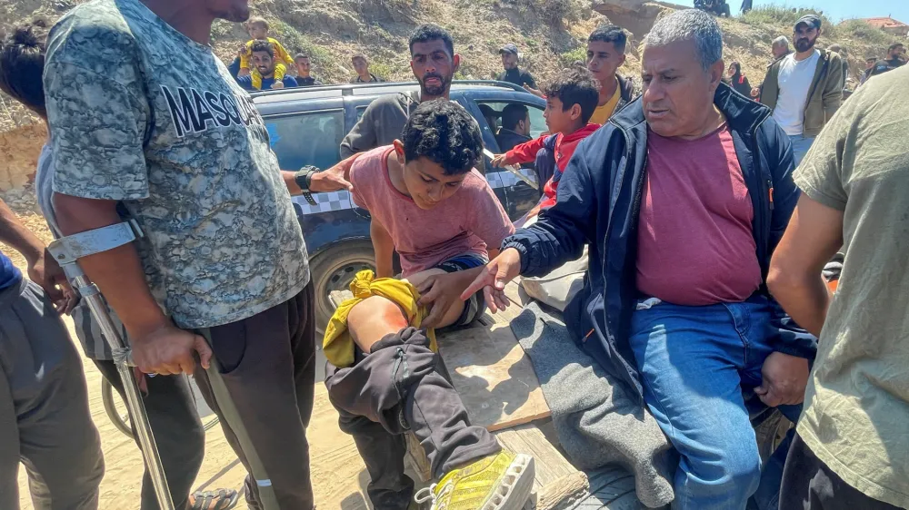 A Palestinian boy, who was displaced by Israel's military offensive on south Gaza, is helped after he got wounded while attempting to return to his home in north Gaza, amid the ongoing conflict between Israel and Hamas, as seen from central Gaza Strip April 14, 2024. REUTERS/Ramadan Abed
