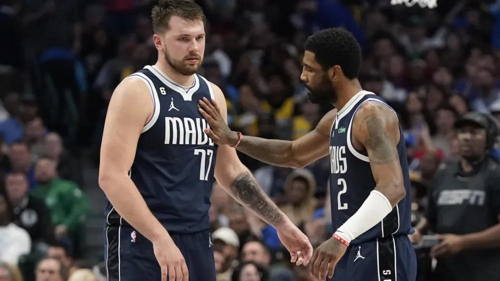 Dallas Mavericks guard Luka Doncic (77) gets a pat from teammate guard Kyrie Irving (2) during the second half of an NBA basketball game against the Los Angeles Lakers in Dallas, Sunday, Feb. 26, 2023. (AP Photo/LM Otero)