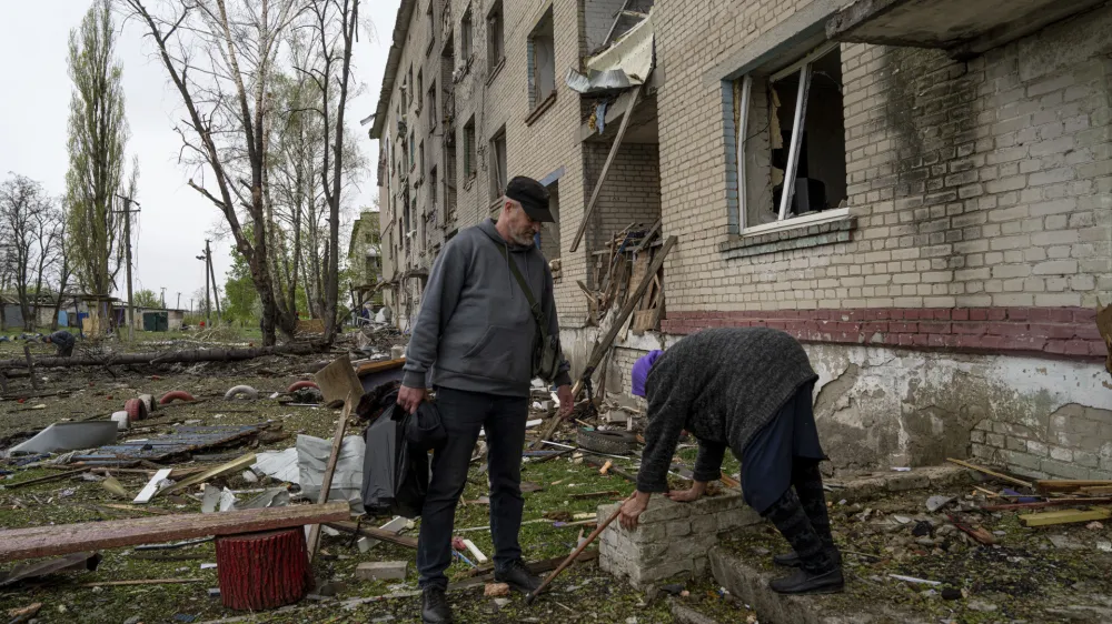 A volunteer helps Olga, 79, walk down some steps from her apartment which was heavily damaged by a Russian airstrike, during her evacuation, in Lukiantsi, Kharkiv region, Ukraine, on Tuesday, April 16, 2024. (AP Photo/Evgeniy Maloletka)