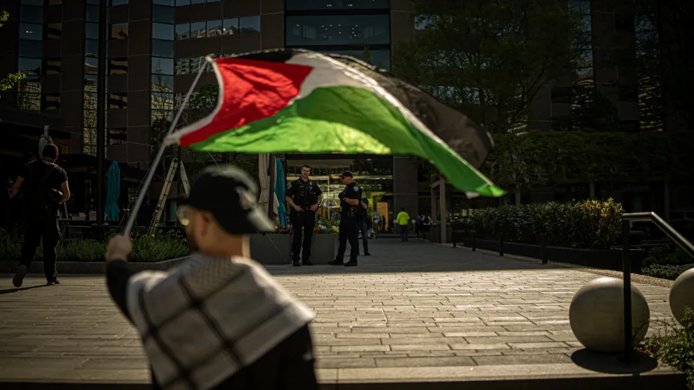 15 April 2024, US, Arlington: A protester holds a flag during a pro-Palestine protest outside Boeing HQ in Arlington against the corporation's supply of military equipment to Israel amidst its war on Gaza. Photo: Natascha Tahabsem/ZUMA Press Wire/dpa