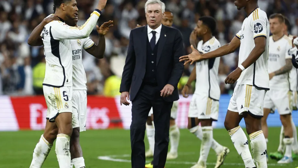 Soccer Football - LaLiga - Real Madrid v FC Barcelona - Santiago Bernabeu, Madrid, Spain - April 21, 2024 Real Madrid's Jude Bellingham, Vinicius Junior and Aurelien Tchouameni celebrate after the match as coach Carlo Ancelotti looks on REUTERS/Susana Vera