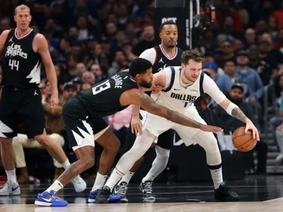Apr 23, 2024; Los Angeles, California, USA; Dallas Mavericks guard Luka Doncic (77) is defended by Los Angeles Clippers forward Paul George (13) during the first quarter of game two of the first round for the 2024 NBA playoffs at Crypto.com Arena. Mandatory Credit: Kiyoshi Mio-USA TODAY Sports