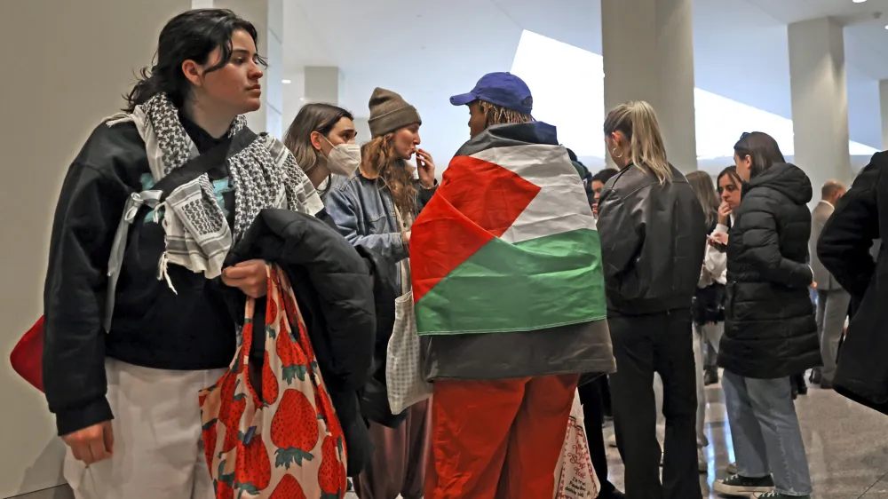 Emerson students stand outside court before being arraigned on Thursday, April 25, 2024 in Boston.  Boston police arrested more than 100 people near Emerson College overnight as officers cleared a tent encampment. (David L Ryan/The Boston Globe via AP)