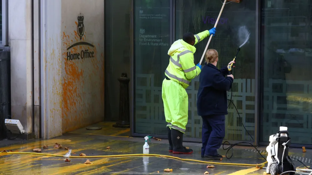 Workers clean up paint the was sprayed onto the Home Office building by "Just Stop Oil" activists in London, Britain, October 31, 2022. REUTERS/Henry Nicholls