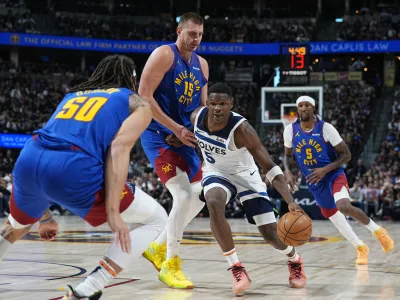Minnesota Timberwolves guard Anthony Edwards (5) drives past Denver Nuggets center Nikola Jokic (15) as forward Aaron Gordon (50) blocks the lane in the second half of Game 1 of an NBA basketball second-round playoff series Saturday, May 4, 2024, in Denver. (AP Photo/David Zalubowski)