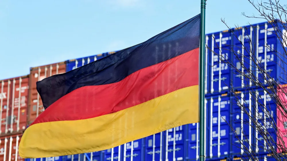 FILE PHOTO: A German flag blows in the wind in front of a stack of containers at the harbour in Hamburg, Germany, February 24, 2022. REUTERS/Fabian Bimmer/File Photo
