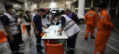 Members of a rescue team discuss after a London-Singapore flight was diverted to Bangkok due to severe turbulence, in Bangkok, Thailand, Tuesday, May 21, 2024. The plane apparently plummeted for a number of minutes before it was diverted to Bangkok, where emergency crews rushed to help injured passengers amid stormy weather, Singapore Airlines said Tuesday. (AP Photo/Sakchai Lalit)