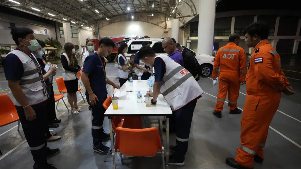 Members of a rescue team discuss after a London-Singapore flight was diverted to Bangkok due to severe turbulence, in Bangkok, Thailand, Tuesday, May 21, 2024. The plane apparently plummeted for a number of minutes before it was diverted to Bangkok, where emergency crews rushed to help injured passengers amid stormy weather, Singapore Airlines said Tuesday. (AP Photo/Sakchai Lalit)