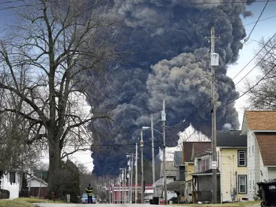 FILE - A black plume rises over East Palestine, Ohio, as a result of the controlled detonation of a portion of the derailed Norfolk Southern trains Monday, Feb. 6, 2023. A federal judge on Tuesday, May 21, 2024, has signed off on the 0 million class action settlement over last year's disastrous Norfolk Southern derailment in eastern Ohio, but many people who live near East Palestine are still wondering how much they will end up with out of the deal. (AP Photo/Gene J. Puskar, File)