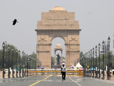 A man walks past the India Gate monument on a hot summer day in New Delhi, India, Monday, May 27, 2024. (AP Photo/Manish Swarup)