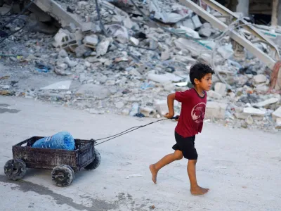 FILE PHOTO: A Palestinian child pulls a water container, amid the ongoing conflict between Israel and Hamas, in southern Gaza City, in the Gaza Strip, June 3, 2024. REUTERS/Mohammed Salem/File Photo