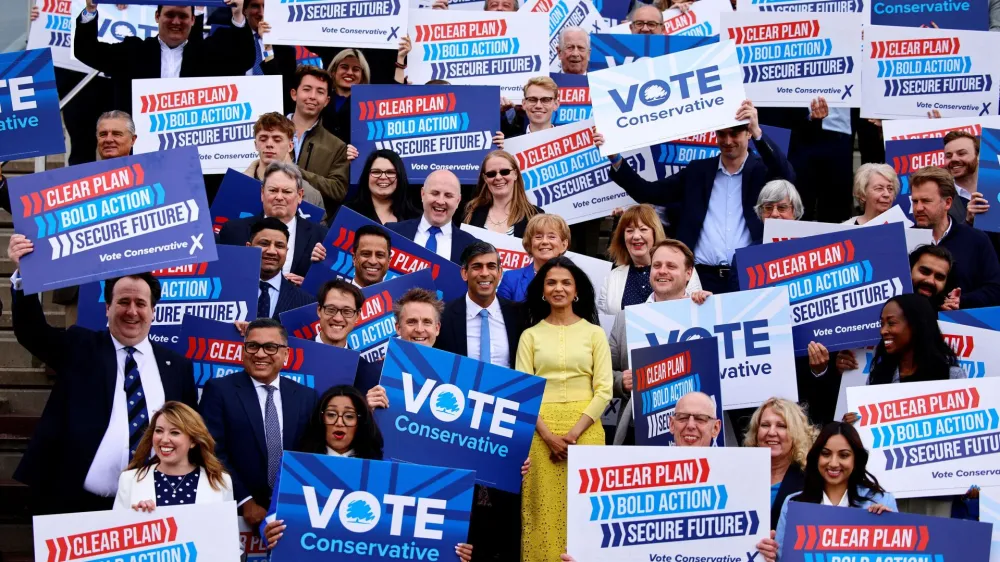Britain's Prime Minister and Conservative Party leader, Rishi Sunak, and his wife Akshata Murty pose with supporters as Sunak launches the Conservatives' general election manifesto in Silverstone, Britain June 11, 2024.   BENJAMIN CREMEL/Pool via REUTERS